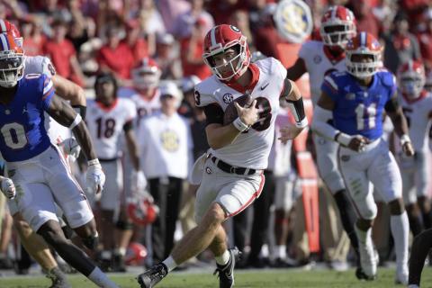 Georgia quarterback Stetson Bennett (13) scrambles for yardage in front of Florida safety Trey Dean III (0) and linebacker Mohamoud Diabate (11) on Oct. 30 in Jacksonville. (PHELAN M. EBENHACK/Associated Press))