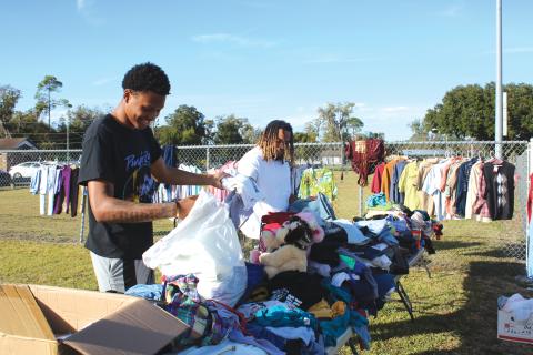 D’Andre Jefferson (left) and Thomas Williams sort through clothes and other goods Wednesday. (TONY BRITT/Lake City Reporter)