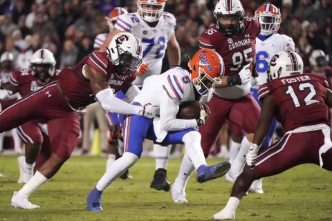 Florida quarterback Emory Jones (5) runs with the ball as South Carolina linebacker Brad Johnson, left, reaches for him during Saturday's game in Columbia, S.C. (SEAN RAYFORD/Associated Press)