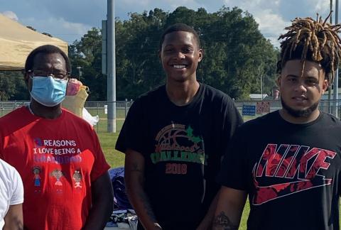 Dr. Tommy Randolph (from left), D’Andre Jefferson and Thomas Williams pose at last year’s clothing drive. (COURTESY)