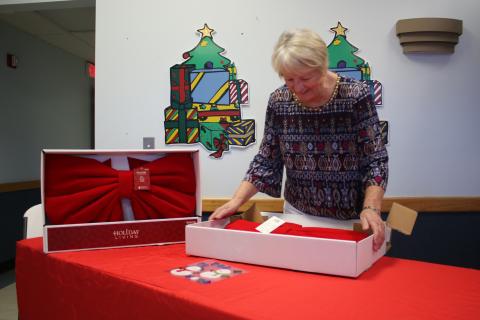 Christmas Dream Machine founder and director Meally Jenkins opens up boxes of giant bows as part of her preparations for this year’s event at 1445 SW Main Boulevard. (TONY BRITT/Lake City Reporter)