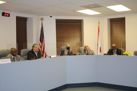 Members of the Lake City Council listen to a speaker at the podium during Monday's meeting. (TONY BRITT/Lake City Reporter)