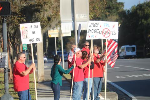 FPL employees and their families protest on the corner of Duval Street and Marion Avenue Wednesday afternoon over vaccine mandates at Florida Power and Light. (TONY BRITT/Lake City Reporter)