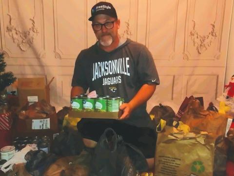 John Cole III, CEO of Saving Our Children, shows off the donated food items that will be given out to local families on Nov. 20. (TONY BRITT/Lake City Reporter)