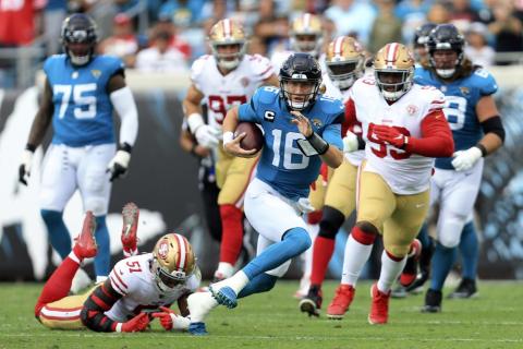 Jacksonville Jaguars quarterback Trevor Lawrence scrambles for yardage as he gets away from San Francisco 49ers linebacker Azeez Al-Shaair (51) and defensive tackle D.J. Jones, right, during Sunday's game in Jacksonville. (MATT STAMEY/Associated Press)