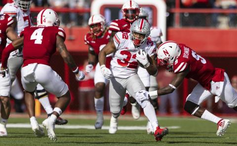 Ohio State's TreVeyon Henderson (32) rushes against Nebraska's Myles Farmer (4) and Marquel Dismuke (9) during Saturday’s game at Memorial Stadium in Lincoln, Neb. Ohio State defeated Nebraska 26-17. (REBECCA S. GRAZT/Associated Press)