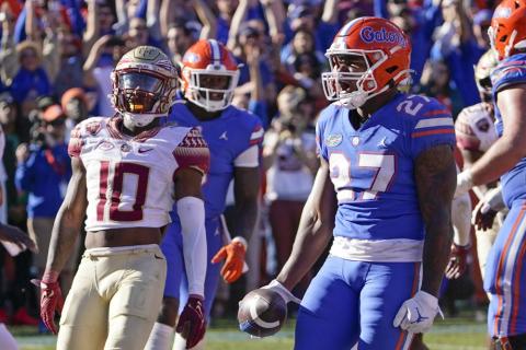 Florida running back Dameon Pierce (27) celebrates a 3-yard touchdown run as Florida State defensive back Jammie Robinson (10) looks on during Saturday's game in Gainesville. (JOHN RAOUX/Associated Press)