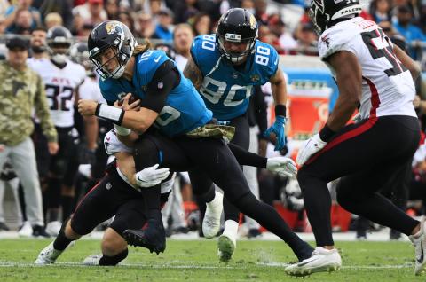 Jacksonville Jaguars quarterback Trevor Lawrence is tackled by Atlanta Falcons safety Erik Harris at TIAA Bank Field on Nov. 28 in Jacksonville. (COREY PERRINE/Florida Times-Union/TNS)