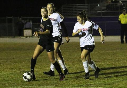 Columbia’s Skyler Ziegaus looks to pass as Fort White’s Riley Karlton chases her down Thursday night. (JORDAN KROEGER/Lake City Reporter)