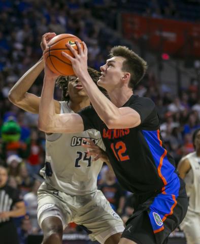 Florida forward Colin Castleton drives on North Florida forward Jadyn Parker during Wednesday's game in Gainesville. (ALAN YOUNGBLOOD/Associated Press)
