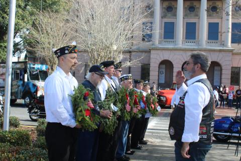 Mike Ziegler (left), holds a wreath for the POW/MIA memorial as he is saluted by Robert Mixon, during Saturday’s local Wreaths Across America event. (TONY BRITT/Lake City Reporter)
