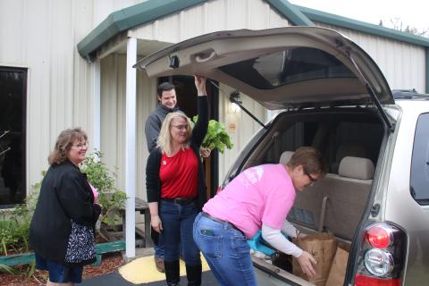 Tammy Sarber (clockwise from left), Chris Walters, Sadie House and Amy Johnson load food into a client’s van during the Christian Service Center annual Christmas Basketball give-away Monday morning. (TONY BRITT/Lake City Reporter)