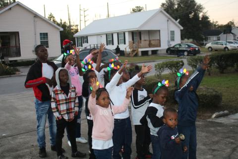 Children gather in the driveway of an Aberdeen home to sing Christmas carols on Wednesday afternoon. (TONY BRITT/Lake City Reporter)