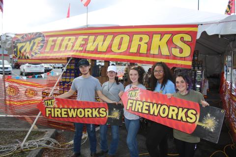 Columbia High School FFA students Logan Russ (from left), Kenzie Dungan, Kaylen Dungan, Cayden Hall and Emili Jones hold two TNT fireworks signs while promoting fireworks sales for the Columbia High School FFA fundraiser. (TONY BRITT/Lake City Reporter)