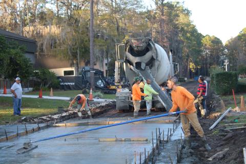Construction workers pour and level cement near the Florida Gateway College’s Teacher Academy Building Monday afternoon. Pedestrian walkways around campus are being improved as part of a $380,000 construction project. (TONY BRITT/Lake City Reporter)