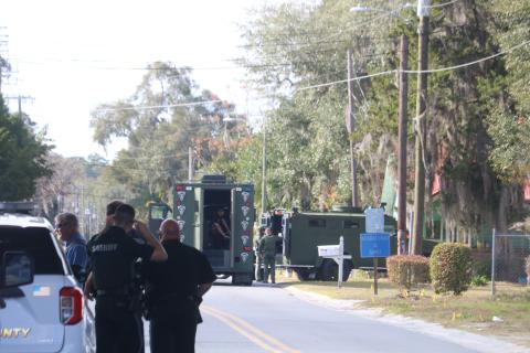 Members of the Columbia County Sheriff’s Office stand by as a pair of SWAT vehicles set up at the scene of a standoff Monday afternoon. (TONY BRITT/Lake City Reporter)
