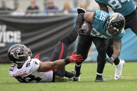 Jacksonville Jaguars running back James Robinson is tackled by Atlanta Falcons linebacker James Vaughters on Nov. 28 in Jacksonville. (PHELAN M. EBENHACK/Associated Press)