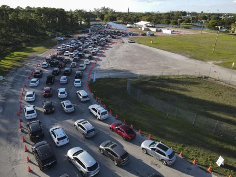 In this photo taken by a drone, cars wait in long lines at a drive-up covid-19 testing center at Tropical Park, Wednesday, Dec. 29, 2021, in Miami. (REBECCA BLACKWELL/Associated Press)