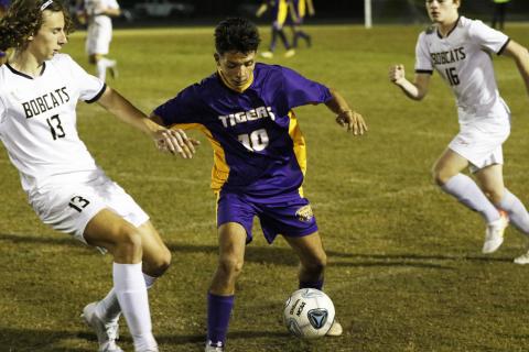 Jason Caballero gathers possession of the ball as Buchholz’s Eduardo Santos rushes in to defend on Friday night. (JORDAN KROEGER/Lake City Reporter)