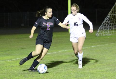 Columbia’s Hannah Dicks looks to pass to a teammate as Leon’s Emerson Jones rushes over to defend during Friday’s match. (MORGAN MCMULLEN/Lake City Reporter)