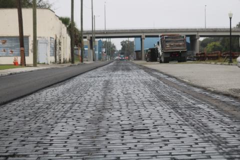 A layer of sealant covers brick pavers on Northwest Railroad Street on Wednesday afternoon as Anderson Columbia Construction Company workers resurface the roadway. (TONY BRITT/Lake City Reporter)