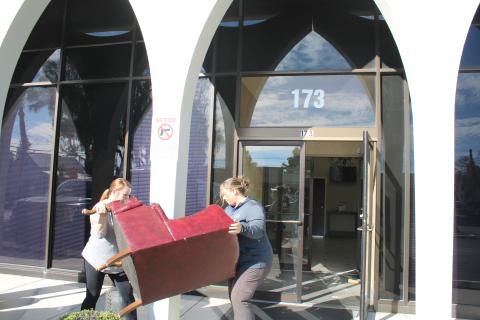 Lake City Customer Service Manager Katrina Medearis (left) and Brandy McGhin, city customer service coordinator, move furniture into the Millennium Bank building Thursday afternoon. (TONY BRITT/Lake City Reporter)
