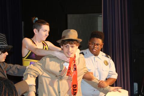 Columbia High School student Kaiden Hodson is grabbed by Colin Jolliffee and Schmari Lockley during Wednesday’s dress rehearsal for the ‘Murder at the Orient Express’ mystery dinner theater production scheduled for Friday night. (TONY BRITT/Lake City Reporter)