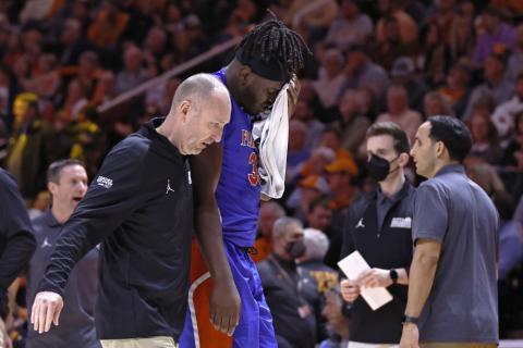 Florida center Jason Jitoboh is led off the court after being injured on a play against Tennessee on Wednesday in Knoxville, Tenn. (WADE PAYNE/Associated Press)