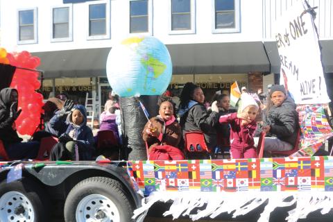 Children on the New Dayspring Missionary Baptist Church float hold flags representing various nations during the Dr. Martin Luther King Jr. parade on Jan. 20, 2020. (FILE)