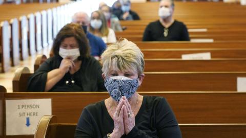 Diane Leahy prays with others before receiving the second dose of the Moderna covid-19 vaccine at St. Patrick Catholic Church on March 1, 2021, in Miami Beach. (MARTA LAVANDIER/Associated Press)