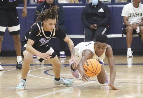 Columbia guard Jerome Carter dives for a loose ball against Godby during the Hitchcock’s Challenge at Legacy Park on Dec. 30 in Alachua. (JORDAN KROEGER/Lake City Reporter).