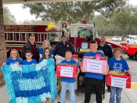 Columbia City Elementary students hold up donations they collected as a gift to veterans at the Lake City VA Medical Center. (COURTESY)