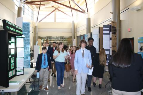Students make their way through a hallway showcasing different science fair projects Thursday afternoon at Florida Gateway College. Students had a chance to look at each other’s projects as judges deliberated their decision. (TONY BRITT/Lake City Reporter)