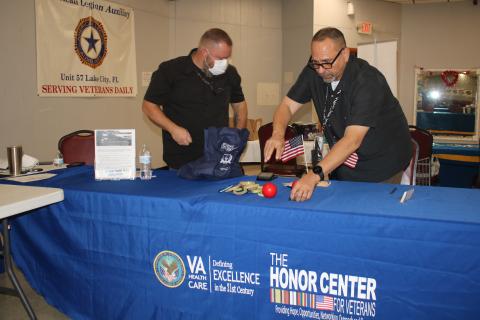 A pair of VA associates set up a table at American Legion Post No. 57 ahead of Thursday’s event. (TONY BRITT/Lake City Reporter)