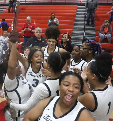 The Fort White girls basketball team hoists the District 6-1A Championship trophy in the air as it celebrates the program’s first district title Friday night. (MORGAN MCMULLEN/Lake City Reporter)