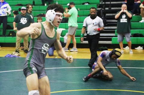 Suwannee wrestler Topher Pearson celebrates after winning the District 2-1A title in he 106 class on Friday. (MORGAN MCMULLEN/Lake City Reporter)