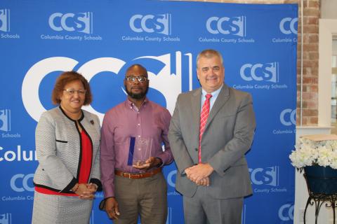 Narrie Smith (from left), Columbia School Board Chair, stands with Virgil Scippio, custodian supervisor at the school district administration building and Lex Carswell, superintendent of schools after Scippio was recognized as the 2022 Columbia School District School Related Employee of the Year during a Thursday afternoon ceremony at the Blanche Hotel. (TONY BRITT/Lake City Reporter)
