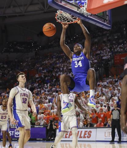 Kentucky forward Oscar Tshiebwe (34) dunks next to Florida forward Colin Castleton (12) during Saturday’s game in Gainesville. (MATT STAMEY/Associated Press)