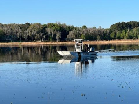 A Suwannee County Sheriff’s Department watercraft searches for the remains of Paul Gibson. Patrols found the 35-year-old’s body in Peacock Lake on Monday. (COURTESY)