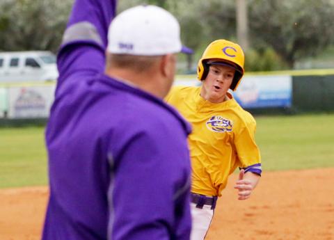 Columbia head coach Chris Howard (left) waves home Columbia outfielder Branson Mann as he rounds third base for a run against Gainesville on Friday night. (BRENT KUYKENDALL/Lake City Reporter)