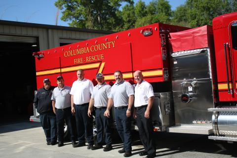 Columbia County Fire Rescue employees Cody Bertram (from left), Arness Thomas, Assistant Chief Lance Hill, Collin Redish, Brian King and Chief Jeff Crawford pose in front of the department’s new tanker trunk. (TONY BRITT/Lake City Reporter)