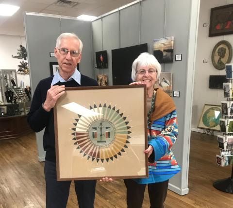 Jim Riley, past president of the Art League of North Florida/Gateway Art Gallery, receives one of the donations of the Harter Trust from Rose Pavey, Administrator. This piece is a Navajo sand painting and will be in the exhibit. (COURTESY)