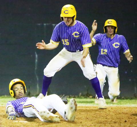 Columbia’s Brayden Thomas slides safely into home plate behind Truitt Todd (15) and Ty Jackson (12), who all scored on Kade Jackson’s bases-clearing double, in the sixth inning of Thursday’s game against Middleburg. (BRENT KUYKENDALL/Lake City Reporter)