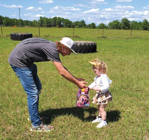 Chapter member Lucky Lloyd helps his niece, Leighton Todd, as she finds Easter eggs on April 15. (COURTESY)