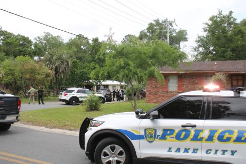 Law enforcement officers surround a residence on the north side of Lake City on Wednesday afternoon. Katrell Hubbard had eluded  custody since March 30 after he fled on foot following a traffic stop. (TONY BRITT/Lake City Reporter)