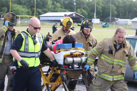 First responders aid a Fort White High School student who was portraying an injured person during a mock crash demonstration Thursday at the school. (TONY BRITT/Lake City Reporter)