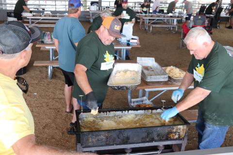 COURTESY A pair of volunteers work on frying up fish during the 11th annual Fins and Pins fundraiser on Saturday. Fins and Pins raised roughly $40,000 during the fish fry and bowling outing. (COURTESY)