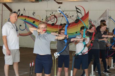 Marta Priller, 11, a member of the Belmont Academy Elementary archery team prepares to fire an arrow while assistant coach Keith Williams looks on. (TONY BRITT/Lake City Reporter)