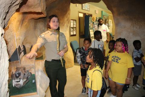 Corie Register, an employee at Ichetucknee Springs State Park, tells Niblack Elementary School students about the American Lion Skull display at the park’s education center Wednesday morning. (TONY BRITT/Lake City Reporter)