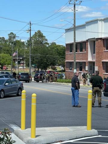 A suspect is escorted by law enforcement toward the Suwannee County Jail after being detained by FBI agents in front of the Suwannee County Courthouse Annex on Monday afternoon. (COURTESY)